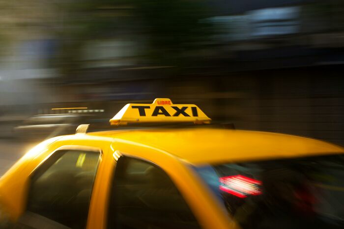 Yellow taxi in motion with a clear taxi sign, capturing the fast pace of out-of-touch moments shamed online.