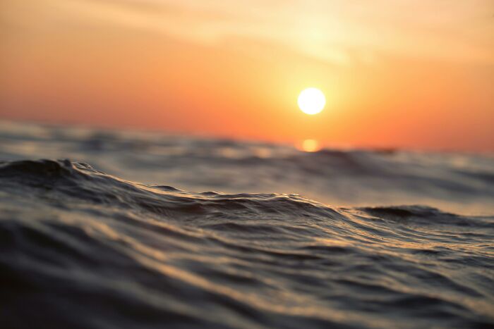Calm ocean waves at sunset, capturing the beauty of low-key pleasures and simple happiness in nature.
