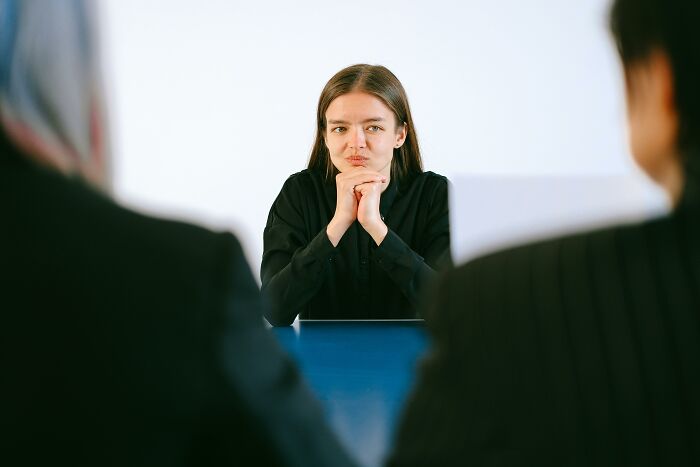 Woman interviewing with two recruiters, reflecting on strange and dumb things heard from recruiters during hiring talks.