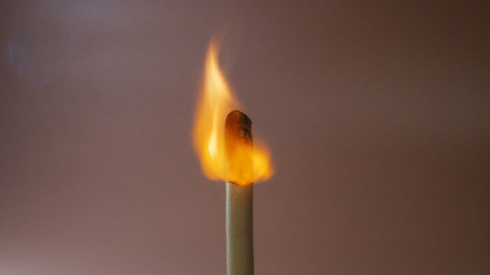 A close-up of a matchstick burning with a bright flame symbolizing wildest life blunders people keep secret.