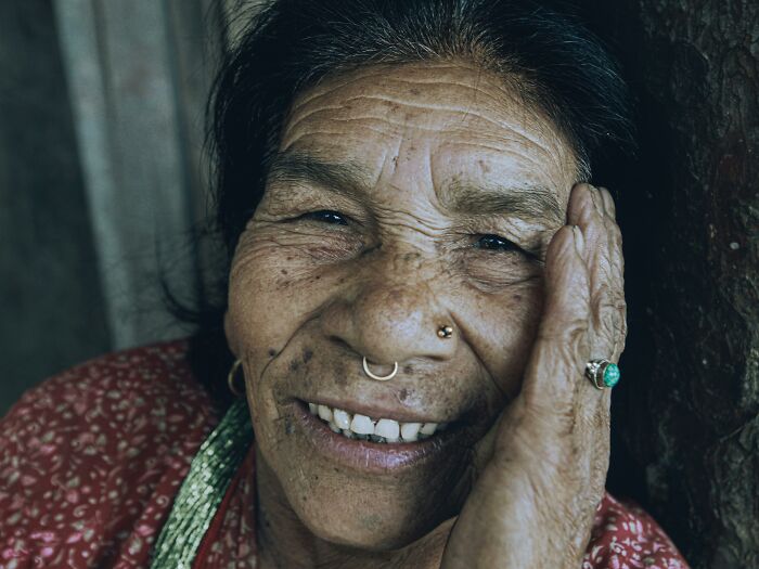 Elderly woman smiling, showing visible body changes that indicate getting older and natural aging signs on skin.