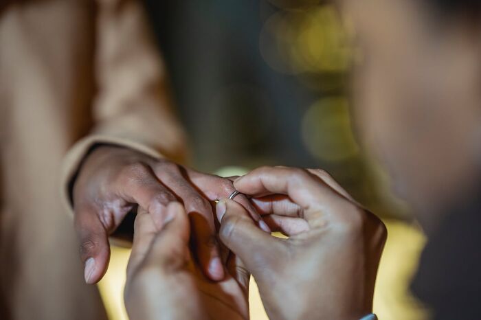 Close-up of a person removing a wedding ring from their partner’s finger illustrating people who called off their wedding.