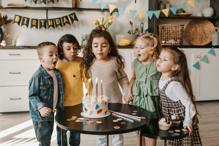 Children celebrating a birthday party blowing out candles, illustrating examples of placebo effect in real life settings.