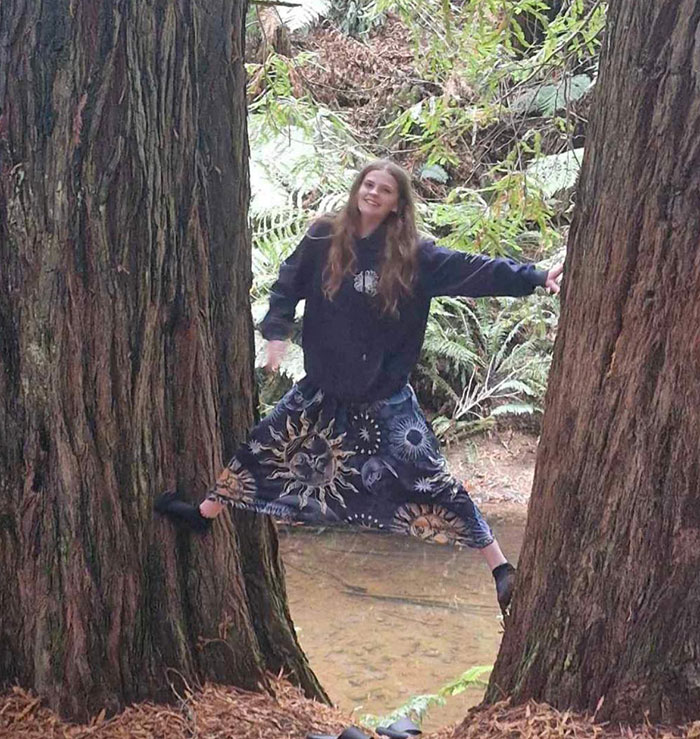 Teen girl balanced between two large trees in forest, related to final text of missing teen who vanished on way to airport. Teen girl balanced between two large trees in forest, related to final text of missing teen who vanished on way to airport.