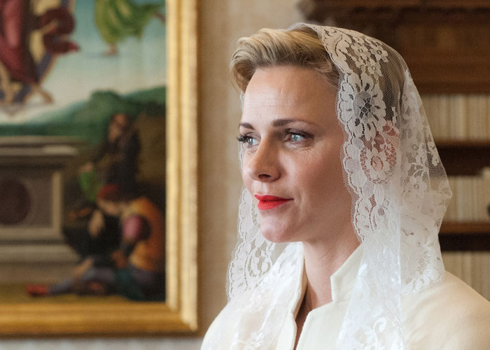 Woman in a white lace veil and outfit, representing one of the seven permitted to wear white when meeting the Pope at the Vatican.