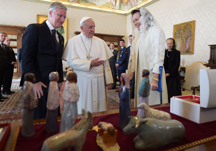 Pope meeting with officials and a woman in a white outfit, highlighting Vatican rules on attire during papal meetings.