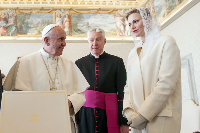 Pope in white robes meeting a woman in white outfit and lace veil, highlighting Vatican rules for women&rsquo;s attire.