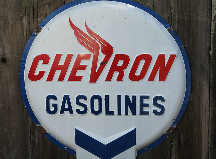 Chevron gasolines vintage sign mounted on a wooden fence, representing a major corporate and PR disaster.