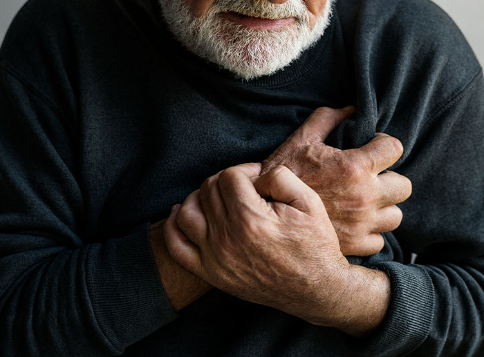 Elderly man clutching chest in pain, symbolizing the severity of corporate and PR disasters in history.