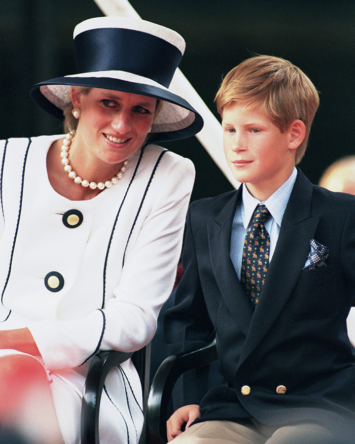 Princess Diana smiling beside a young Prince Harry dressed formally, captured during a public event.