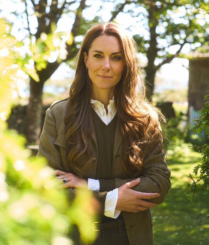 Kate Middleton standing outdoors with crossed arms, right hand belongs to a male editing accusations in portrait.