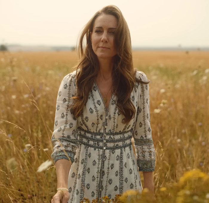 Kate Middleton stands in a field wearing a patterned dress, with editing accusations about the right hand belonging to a male.