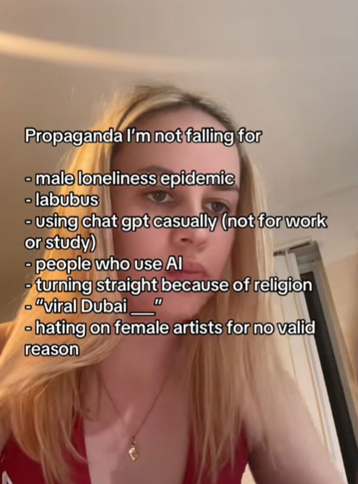 Young woman reading a list of propaganda she refuses to fall for, including topics on AI and social issues.