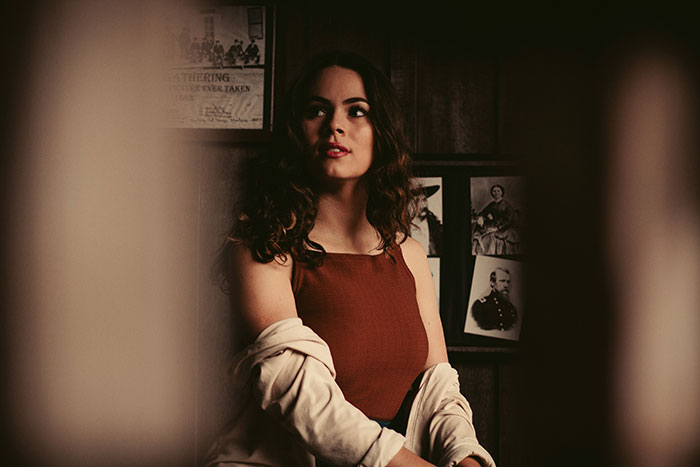 Young woman with a thoughtful expression, symbolizing sibling experiences with narcissists and sociopaths in family dynamics.