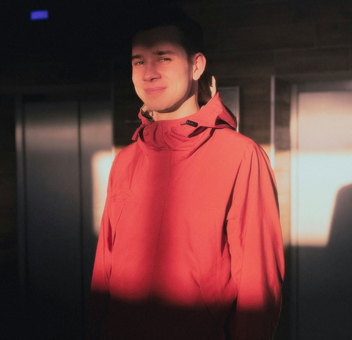 Young man in red jacket standing in sunlight, symbolizing siblings of narcissists and sociopaths sharing their stories.