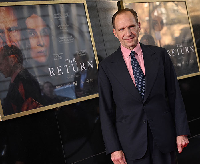 Ralph Fiennes attends a premiere event, dressed in a dark suit and pink shirt, relating to reunion with Francesca Annis.