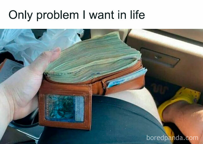 Hand holding a wallet stuffed with cash in a car, illustrating a funny post about barely holding it together.