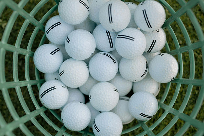 A basket filled with golf balls representing people taking huge risks for no logical reason in a risky situation.
