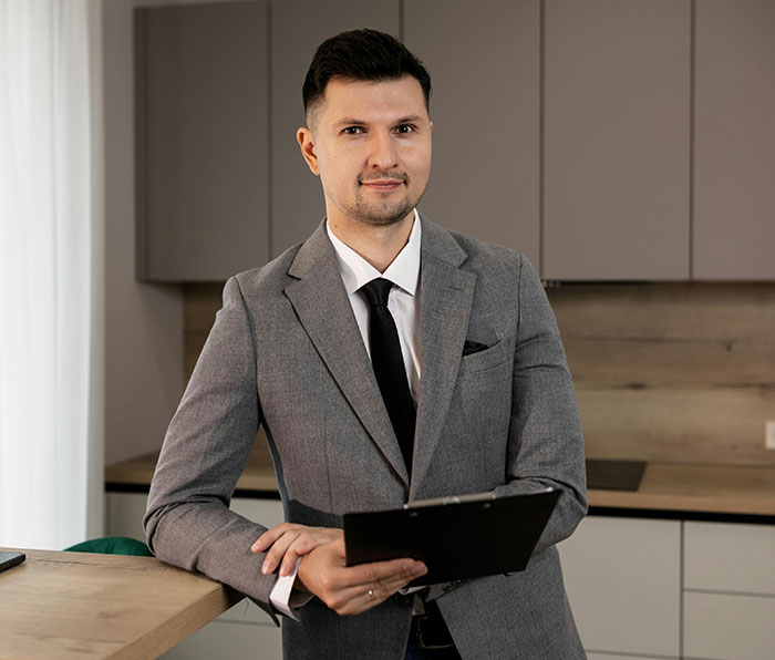 Man in gray suit holding a clipboard, representing a humorous moment related to wind is made by trees concept.