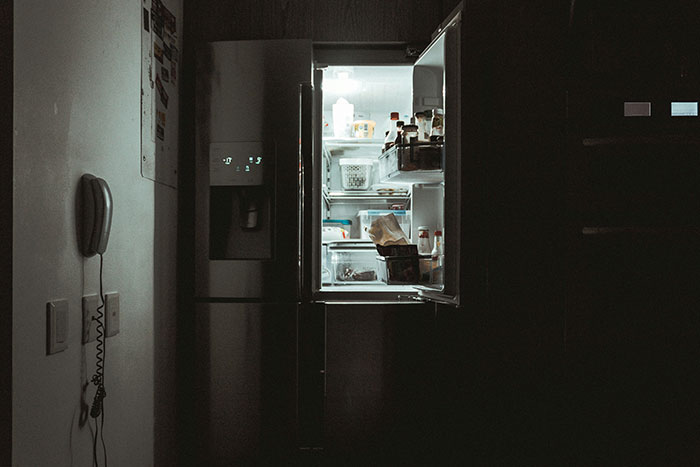 Open refrigerator in a dark kitchen, illustrating a moment of confusion related to wind made by trees concept.