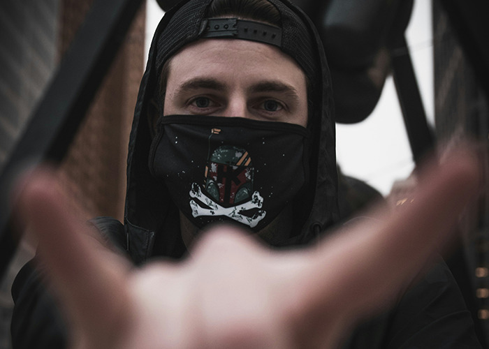 Young man wearing a mask and cap, symbolizing stories of parents disowning their kids and complex family relationships.