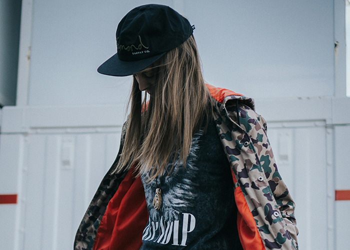 Teenager wearing a camo jacket and black cap, portrayed in an urban setting reflecting stories of parents disowning their kids.
