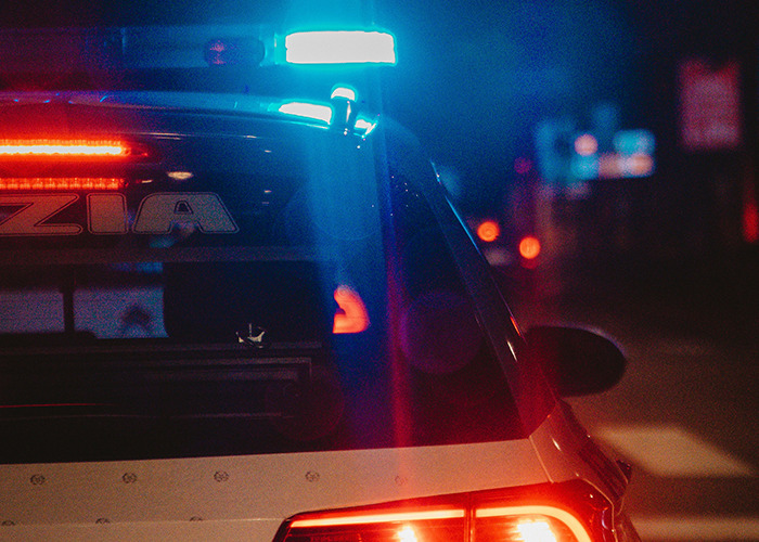 Police car with flashing lights at night, illustrating themes of parents disowning their kids in raw stories.