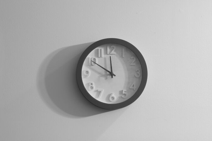 Wall clock showing almost 11 o'clock casting a shadow, representing the concept of a red flag poll.
