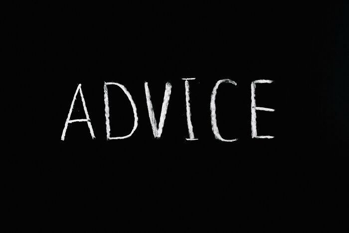 The word advice written in white chalk on a blackboard with a red flag poll concept background