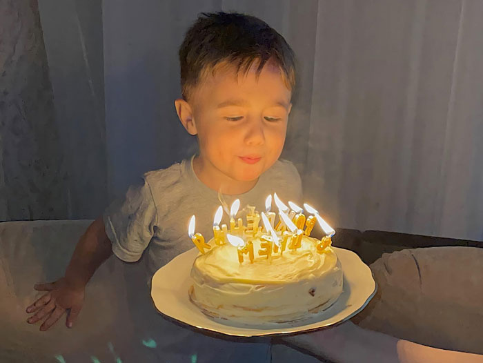 Toddler blowing out candles on birthday cake as mom sets boundaries about it not being his day. Toddler blowing out candles on birthday cake as mom sets boundaries about it not being his day.