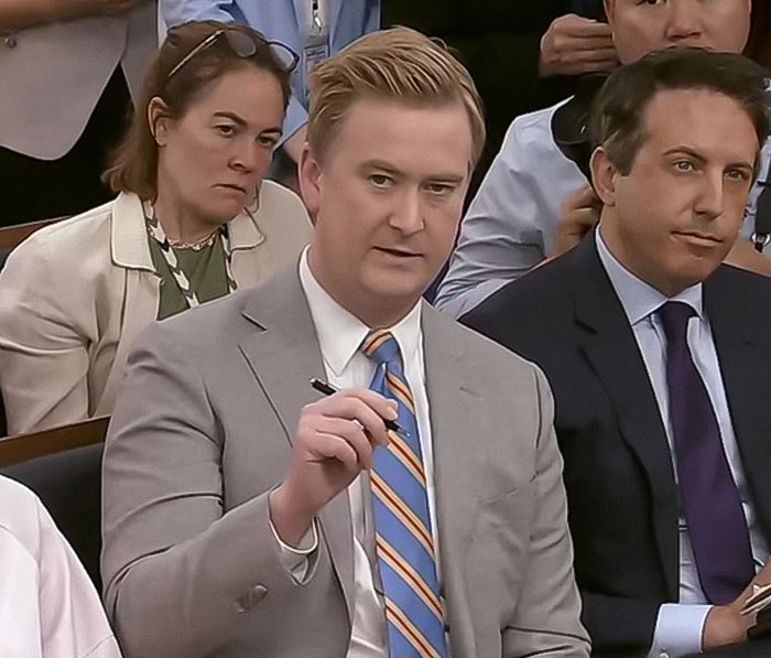 White House press briefing with a reporter in a gray suit discussing President Trump's comments on Taylor Swift.