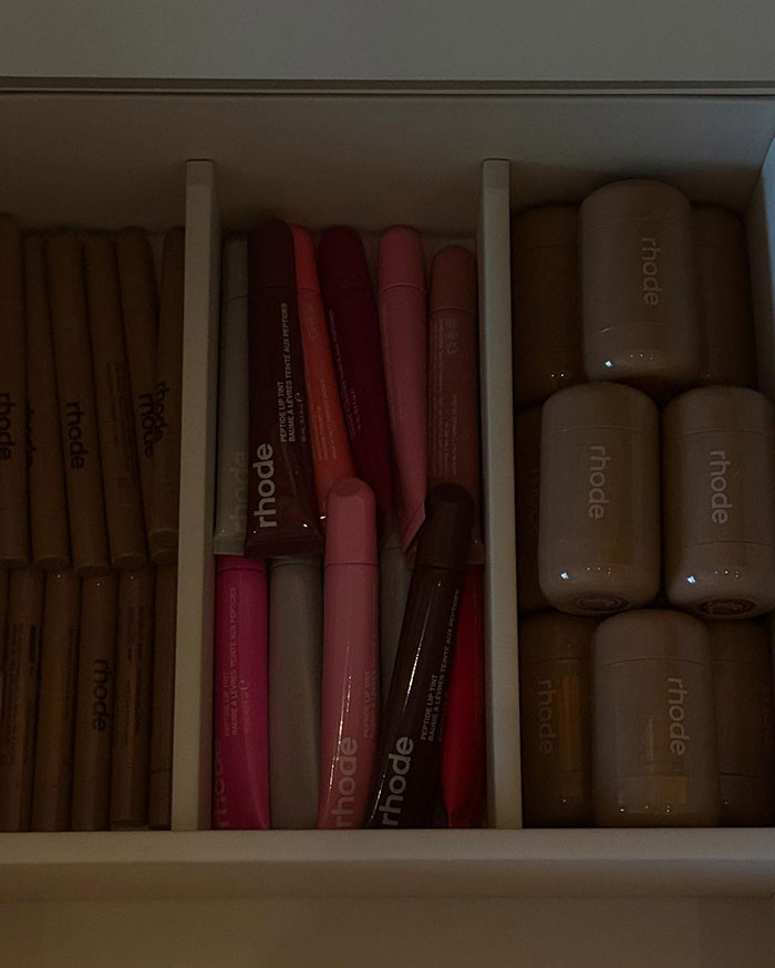 Makeup products neatly arranged in a drawer, showcasing various rhode cosmetics lip and face items.
