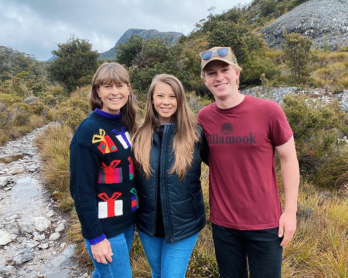 Three people outdoors smiling at the camera, illustrating Robert Irving's family reaction to underwear shoot news. Three people outdoors smiling at the camera, illustrating Robert Irving's family reaction to underwear shoot news.