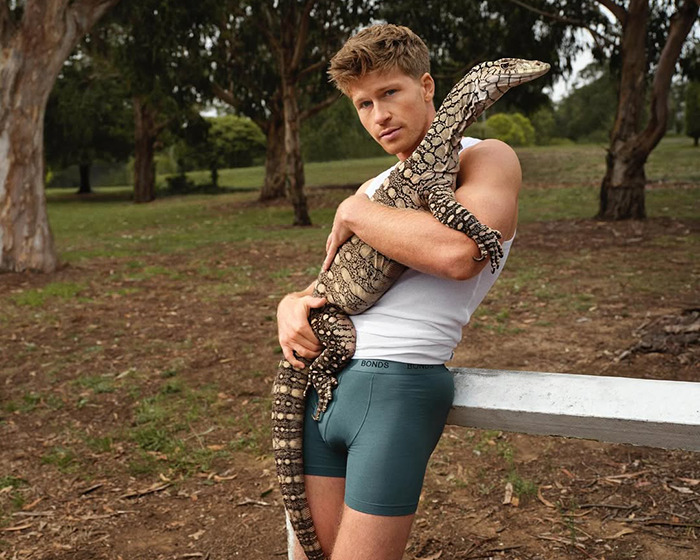Robert Irving posing outdoors in underwear, holding a large lizard, highlighting his family reaction to the shoot. Robert Irving posing outdoors in underwear, holding a large lizard, highlighting his family reaction to the shoot.