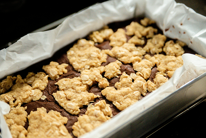 Close-up of a baked oat topping on chocolate dessert in a baking tray, related to middle-aged woman with a shopping habit.