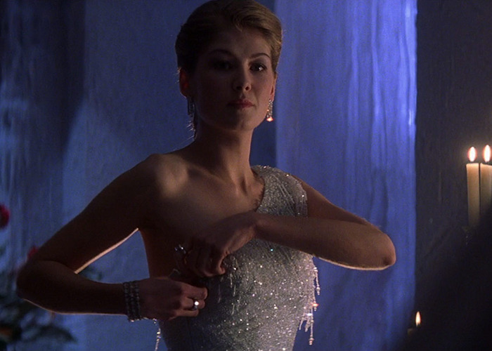 Woman in a sparkly dress unzipping it during a dimly lit scene related to Bond girl auditions and bombshell claims.