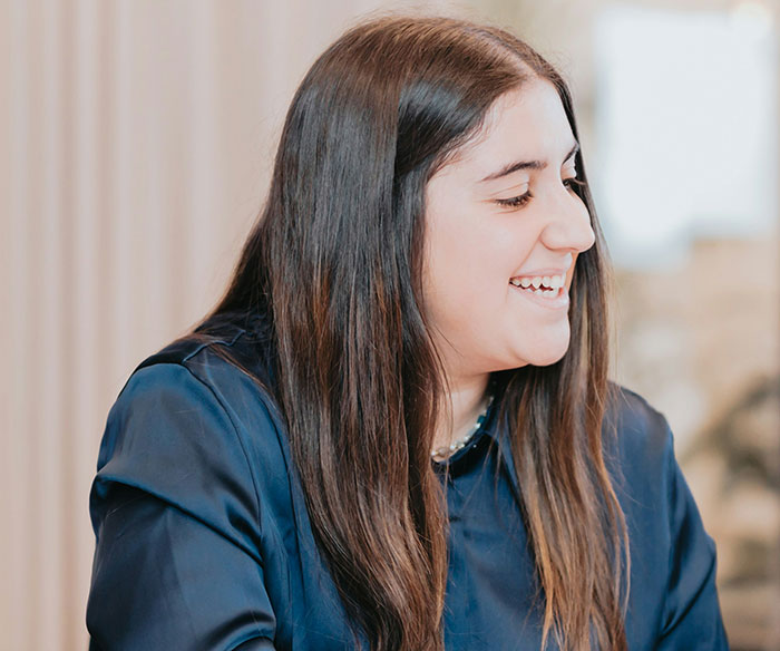 Young woman smiling and engaged in conversation, illustrating confidence and boldness in workplace comebacks to entitled bosses.