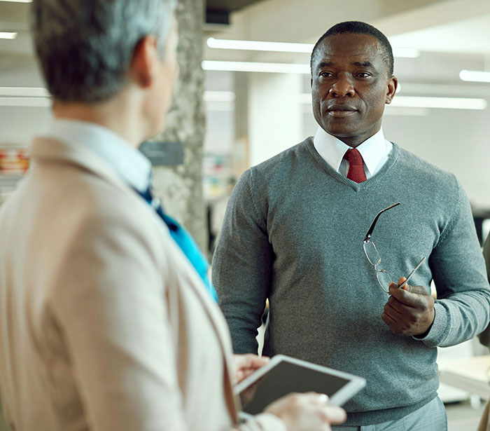Two professionals having a serious discussion in an office, illustrating comebacks to entitled bosses.