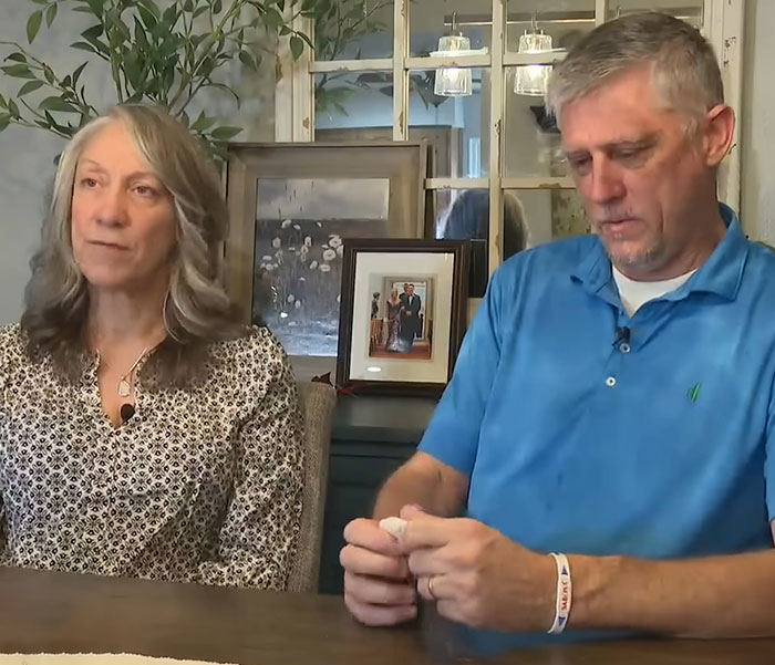 A man and woman sit at a table discussing the impact of LASIK after a tragic suicide note revelation.