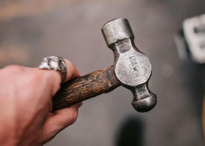 Hand holding a worn hammer demonstrating practical safety tips women picked up the hard way for everyday protection.