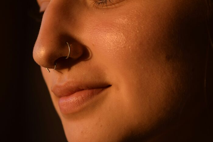 Close-up of a woman’s face with a nose ring, highlighting moments from hilarious and weird things girlfriends do secretly.