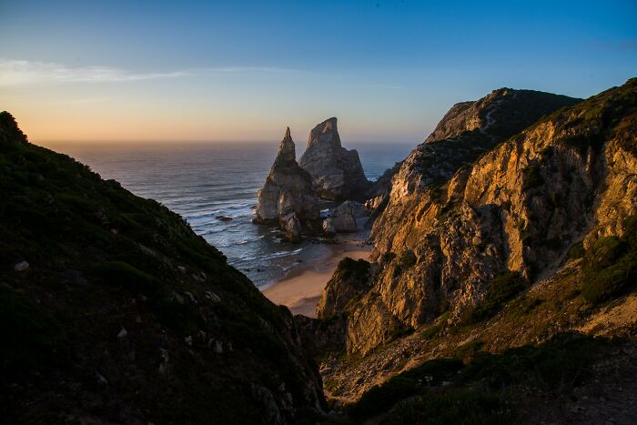 Rock formations on a coastal beach at sunset, showcasing one of the must-see wonders proving the world is full of magic.