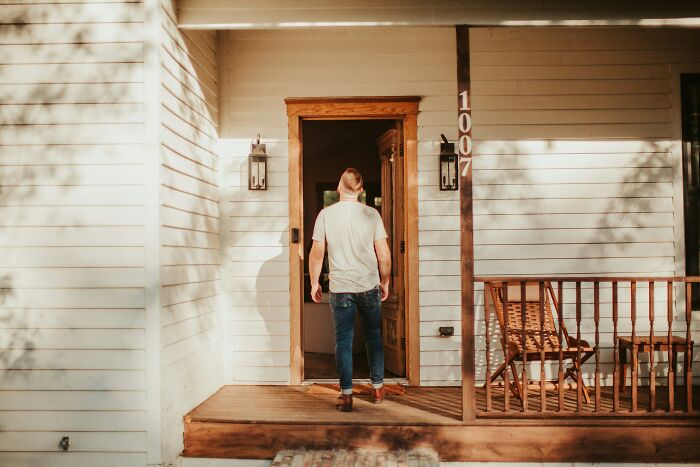 Man entering a cozy home porch, enjoying one of the low-key pleasures that bring simple happiness daily