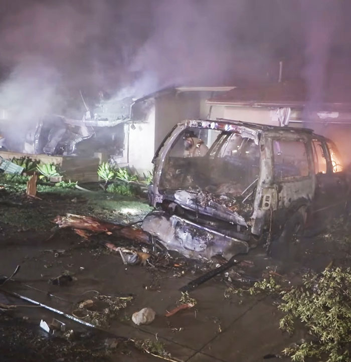 Wreckage of burned vehicle and building remains at San Diego plane crash site linked to famous drummer incident.