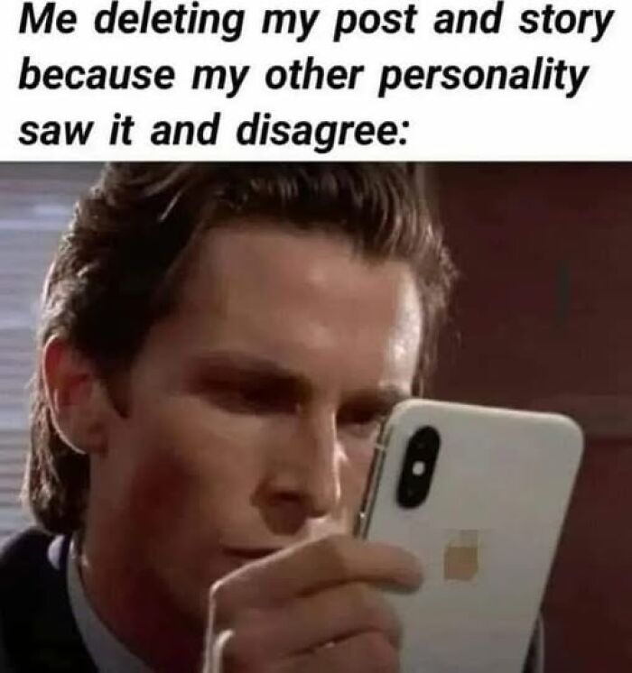 Man intensely looking at phone screen with sarcastic meme about deleting posts due to conflicting personalities shared on Facebook.