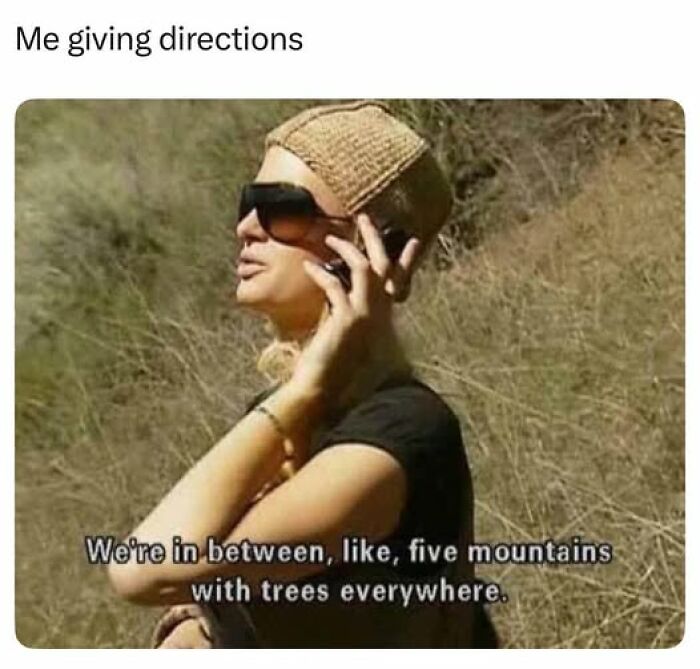 Woman wearing sunglasses and a beige hat giving sarcastic directions about being between five mountains with trees everywhere, hilarious meme.