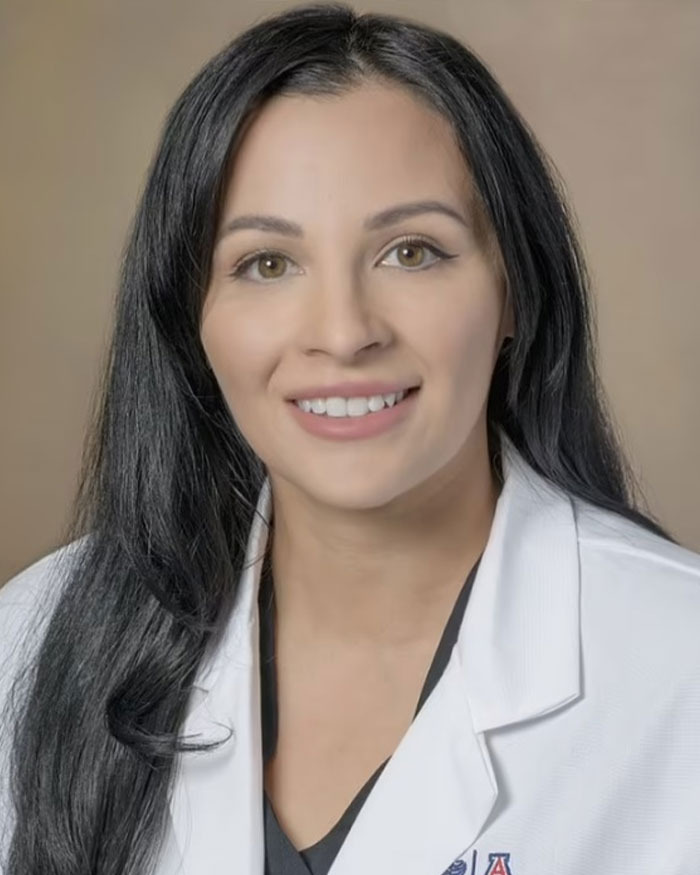 Woman with long dark hair wearing a white coat and smiling, related to marriage revelation man who left toddler near hot car. Woman with long dark hair wearing a white coat and smiling, related to marriage revelation man who left toddler near hot car.