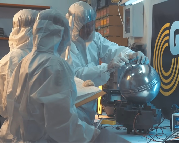 Scientists in protective suits examining a metallic UFO object with ominous writing about origin of birth in a lab setting.