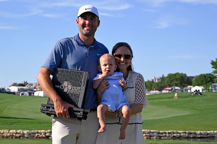 Scottie Scheffler holding golf trophy with family on course, showcasing golf&rsquo;s financial power and rising superstar status