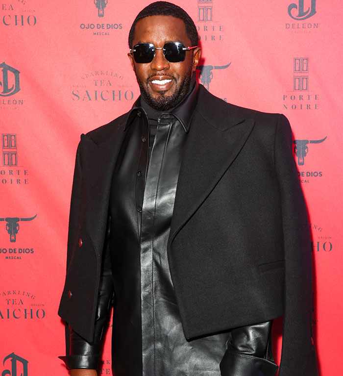 Diddy wearing sunglasses and a black leather outfit at a star-studded party in Ibiza amid trial revelations.